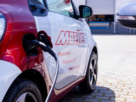 Ein Elektroauto mit dem Schriftzug des Unternehmens Moelle beim Laden