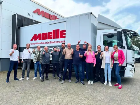Die Belegschaft der Firma Moelle vor einem LKW mit Logo